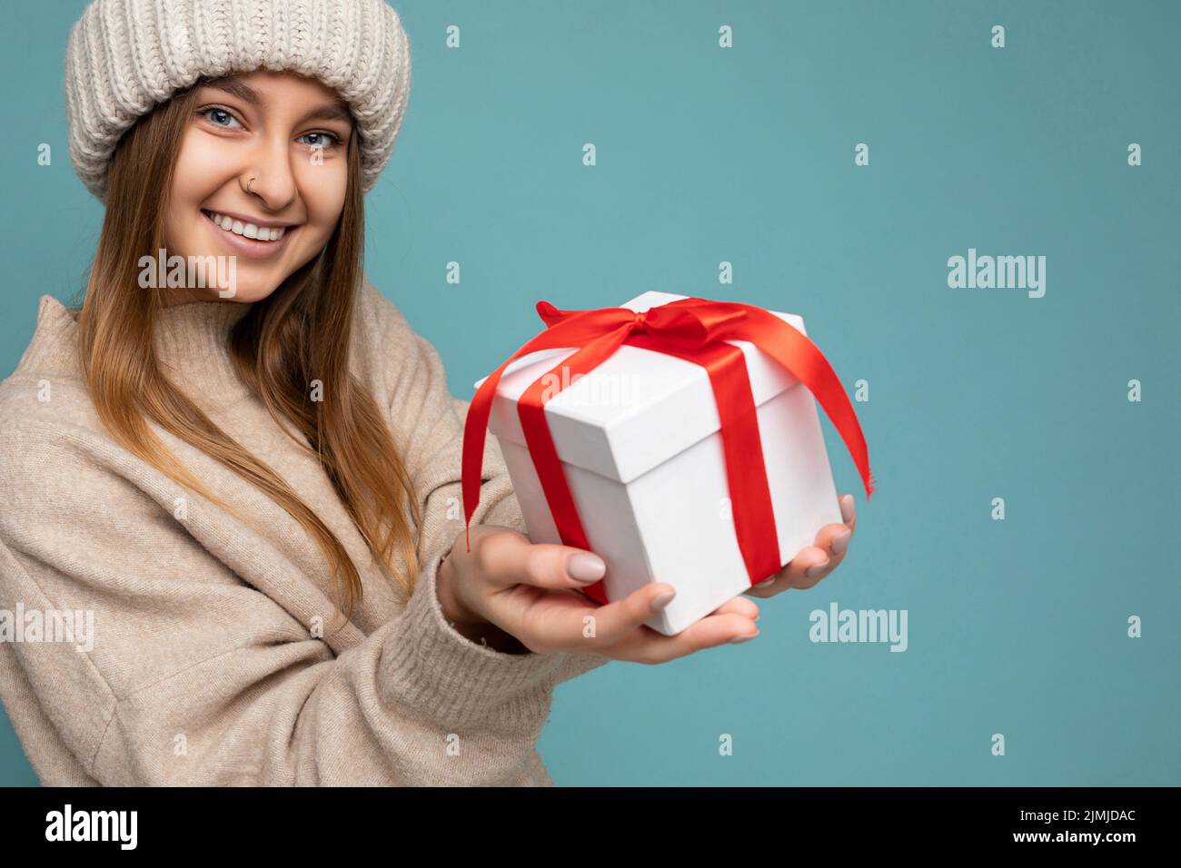 Foto von attraktiven ziemlich schön positiv glücklich lächelnd junge dunkel blonde Frau isoliert auf blauem Hintergrund mit leeren SPAC Stockfoto