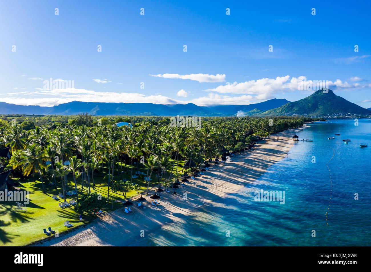 Der Strand von Flic en Flac mit Luxushotels und Palmen, hinter dem Berg Tourelle du Tamarin, Mauritius, Afrika Stockfoto