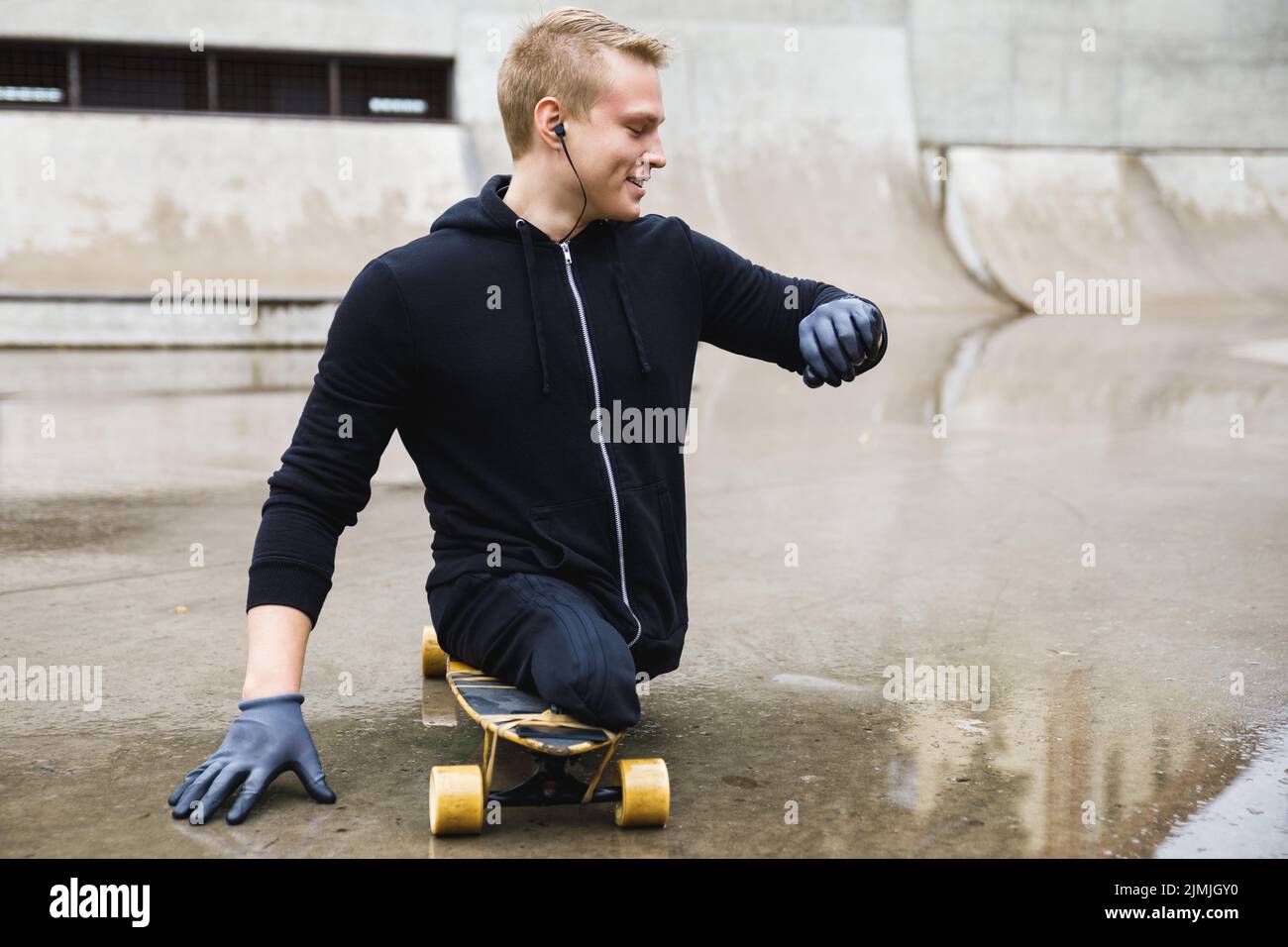 Motivierter Behinderter mit Longboard im Skatepark Stockfoto