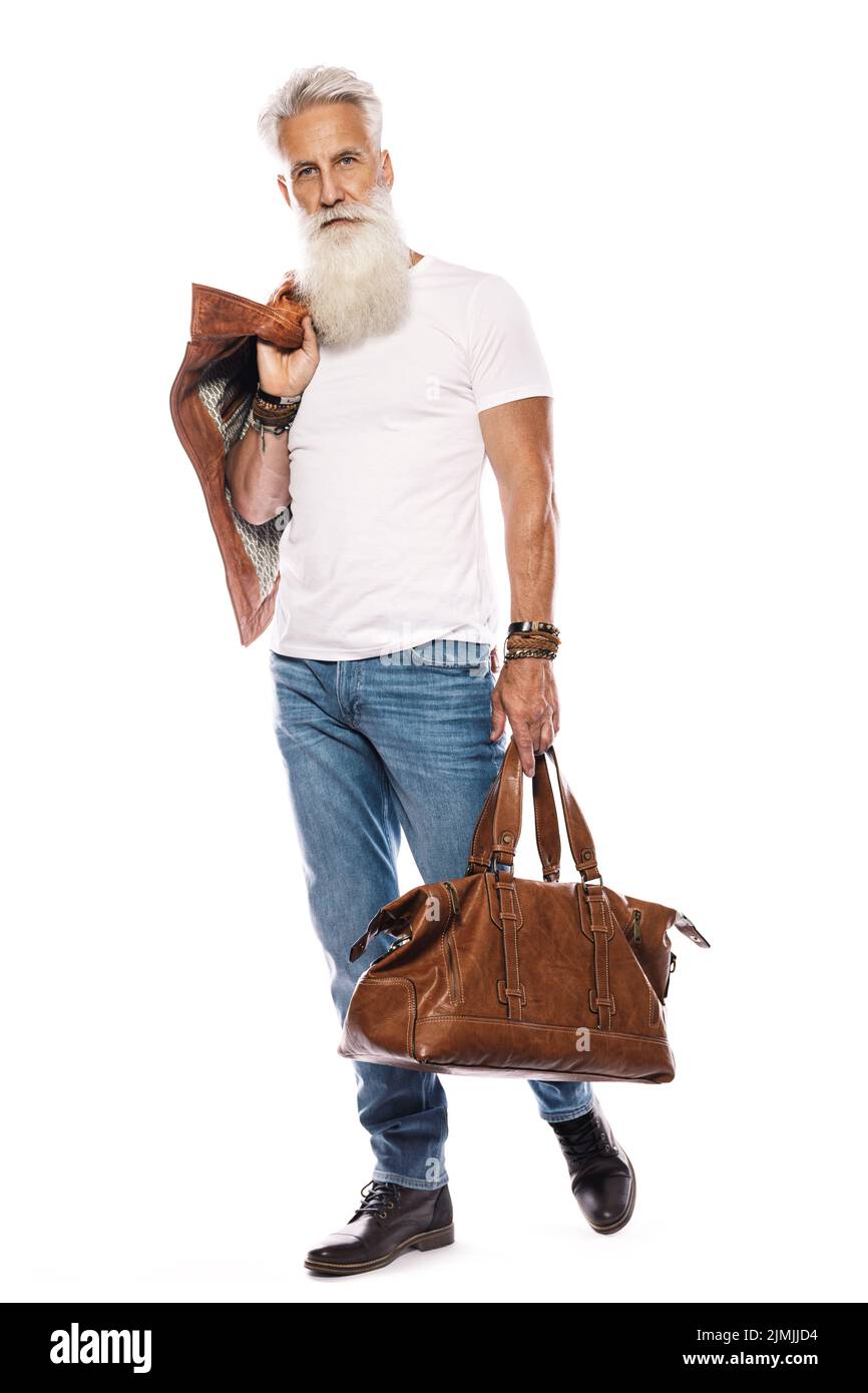 Hübscher bärtiger älterer Mann mit Ledertasche und Jacke auf weißem Hintergrund Stockfoto