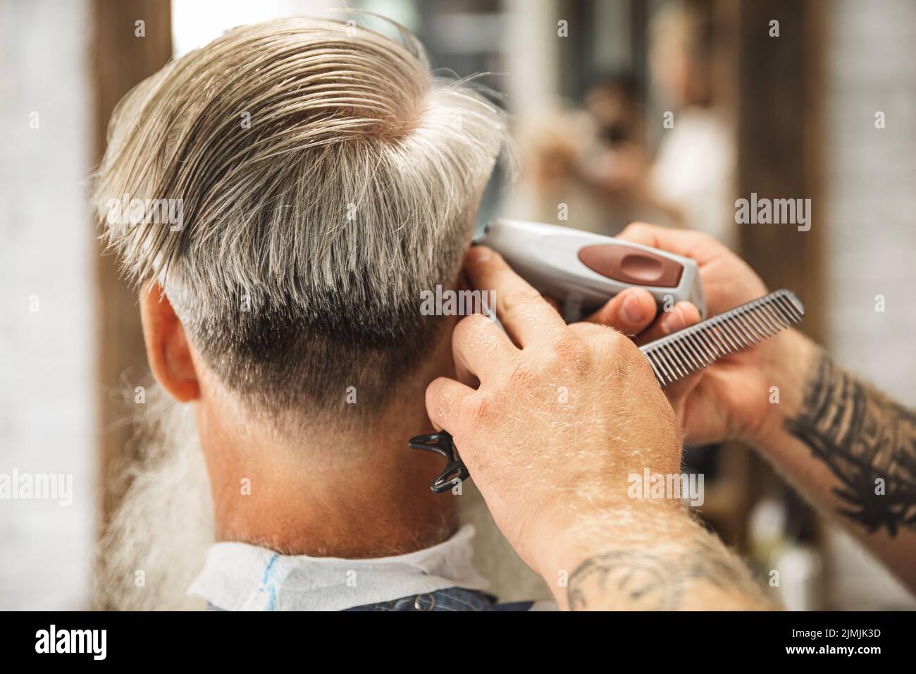 Friseur macht stilvolle Frisur für alten Mann Stockfoto