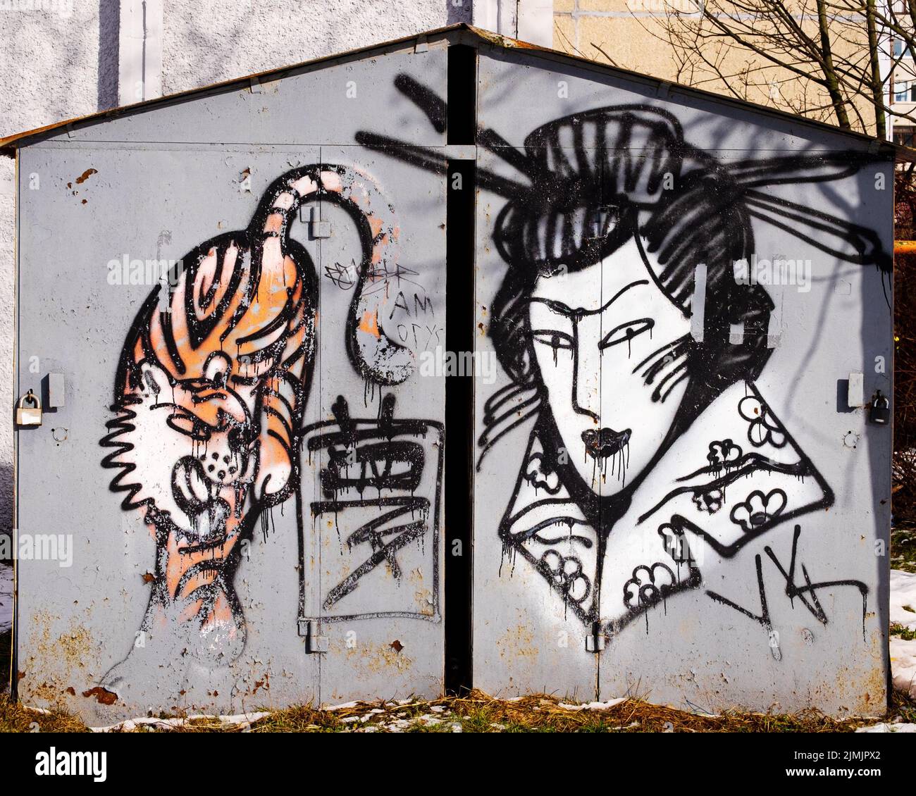 Street Art. Japanische Motive. Zeichnung einer Geisha und eines Tigers an der Wand einer Metallgarage. Stockfoto