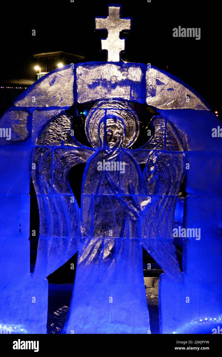 Eisskulptur. Engel mit Flügeln. Das Fest der Erscheinung des Herrn. Die Menschen baden im Eisloch. Vertikal Stockfoto