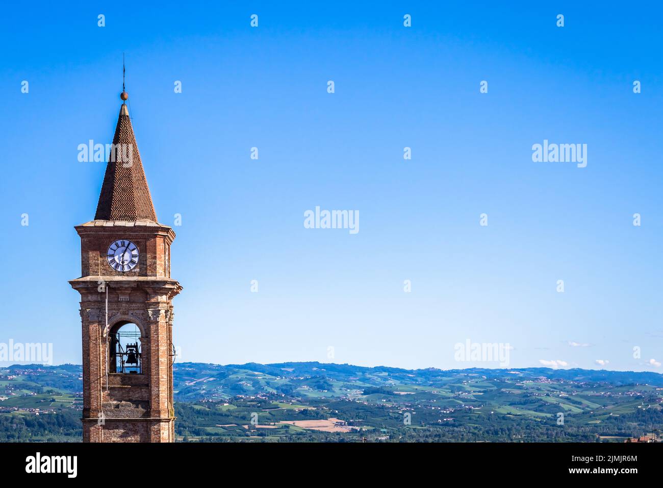 Piemont Hügel in Italien mit landschaftlich reizvoller Landschaft, Weinbergfeld und blauem Himmel. Govone Glockenturm auf der linken Seite. Stockfoto