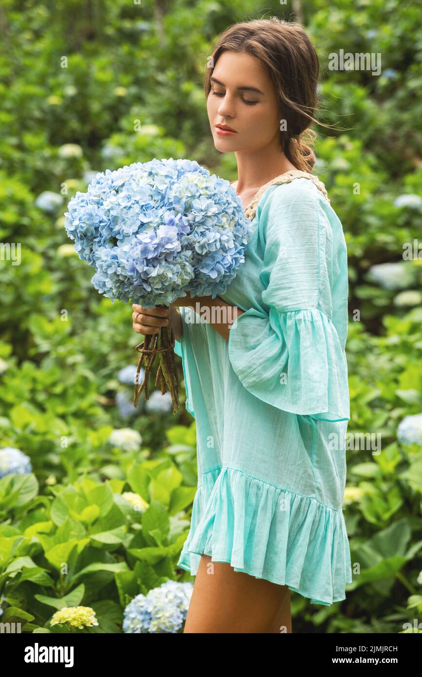 Junge und schöne Frau Floristin sammeln Hydrangea Blumen Stockfoto