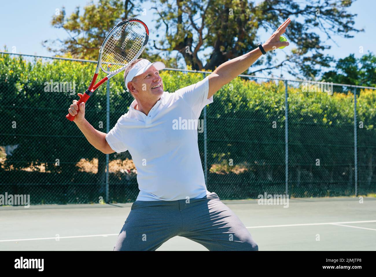 Ein weiteres Spiel gewann. Ein schöner reifer Mann feierte einen Sieg, während er tagsüber Tennis spielte. Stockfoto