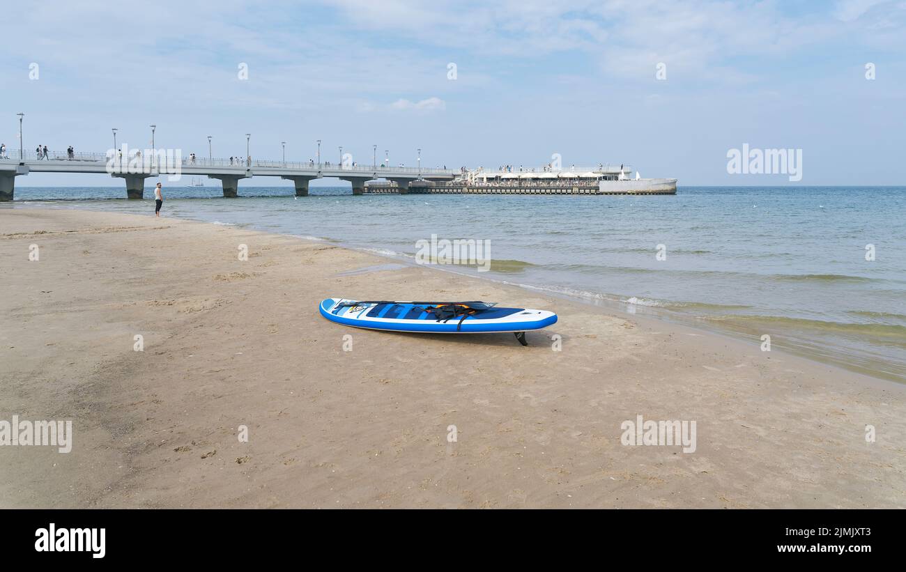 Ostseestrand in der Nähe von Kolobrzeg in Polen mit Stand Up Paddle Board und Pier Stockfoto