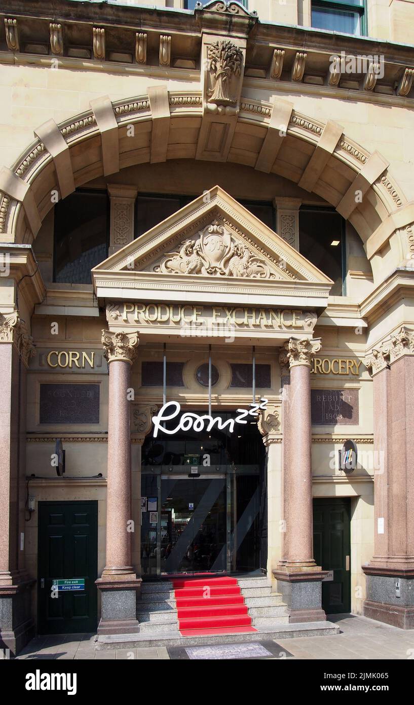 Der Eingang zur Kornbörse in manchester mit einem Schild für das roomzzz Apart Hotel über der Tür Stockfoto