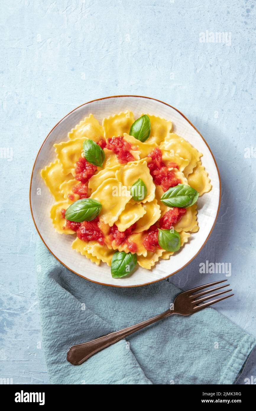 Ravioli mit Tomatensauce und frischen Basilikumblättern, von oben geschossen Stockfoto