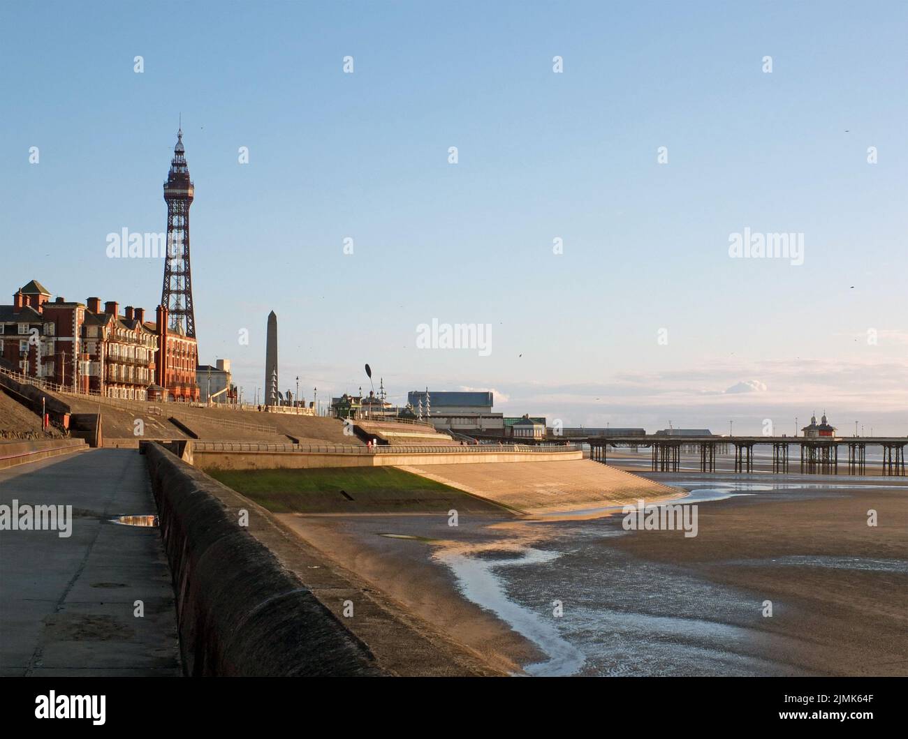 Blick auf den blackpool Tower und den Südpier von der Promenade mit Stadtgebäuden bei Nachmittagssonne Stockfoto