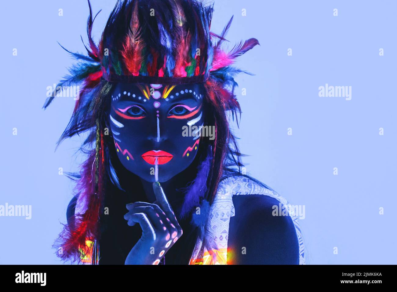 Modell in Bild von Native american mit Neon-Make-up, die von fluoreszierender Farbe in ultraviolettem Licht gemacht. Stockfoto
