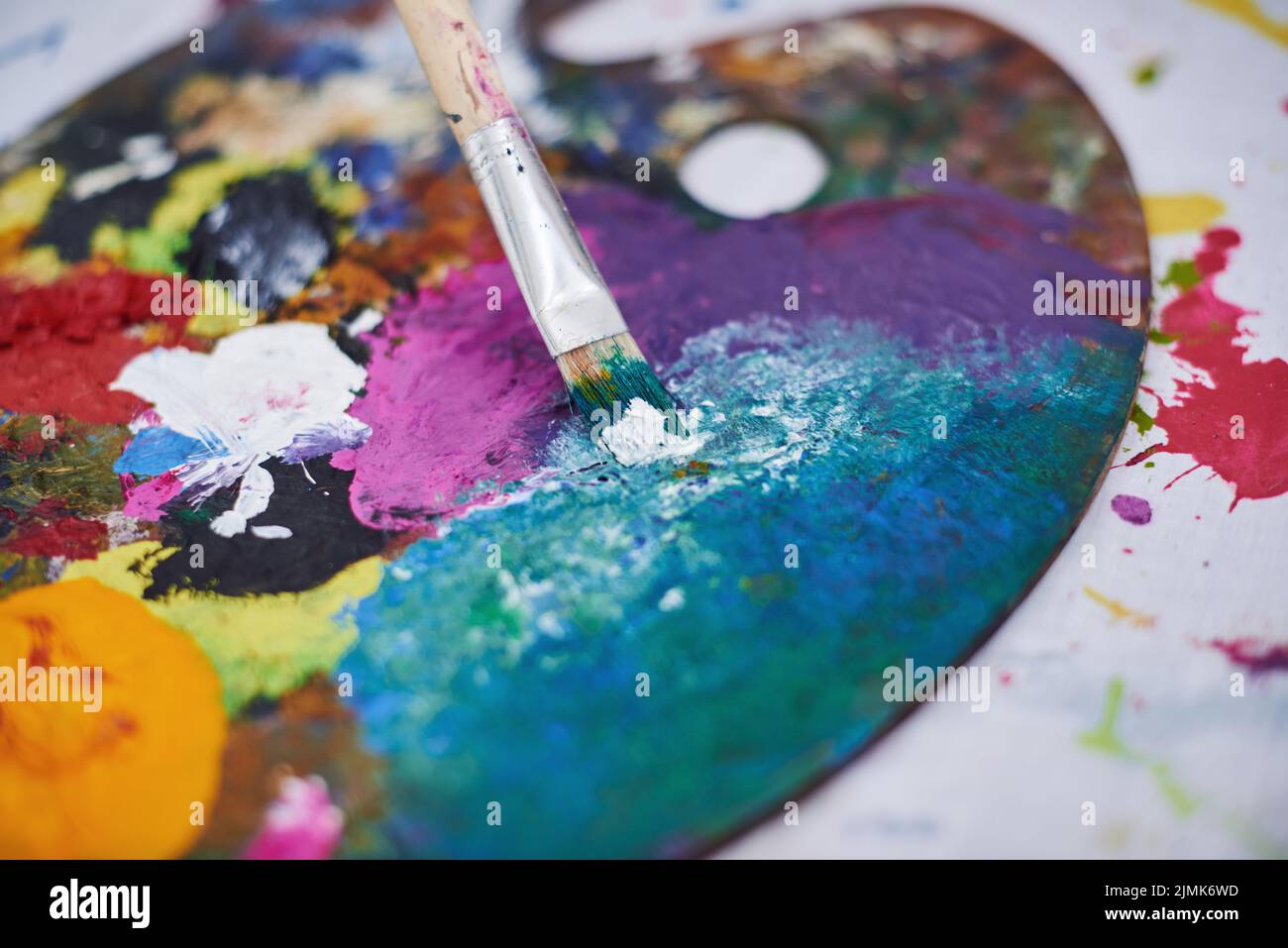 Wir leben in einer bunten Welt. Stillleben eines Pinsels und einer gebrauchten Künstlerpalette. Stockfoto