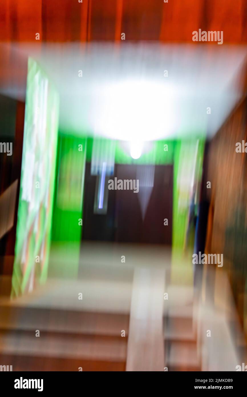 Unschärfende Ansicht des beleuchteten Nachteingangs. Ein Glitch in den Augen eines Betrunkenen oder Drogenabhängigen. Stockfoto