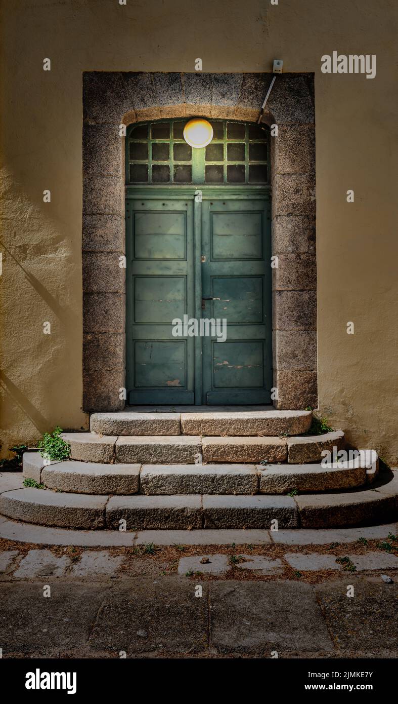 Doppelte Holztür mit Lampe beleuchtet. Stockfoto