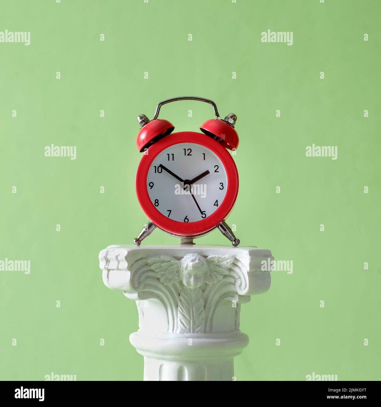 Wecker Retro-Uhr und antike Säule als Podium und Sockel für Anzeige. Stockfoto