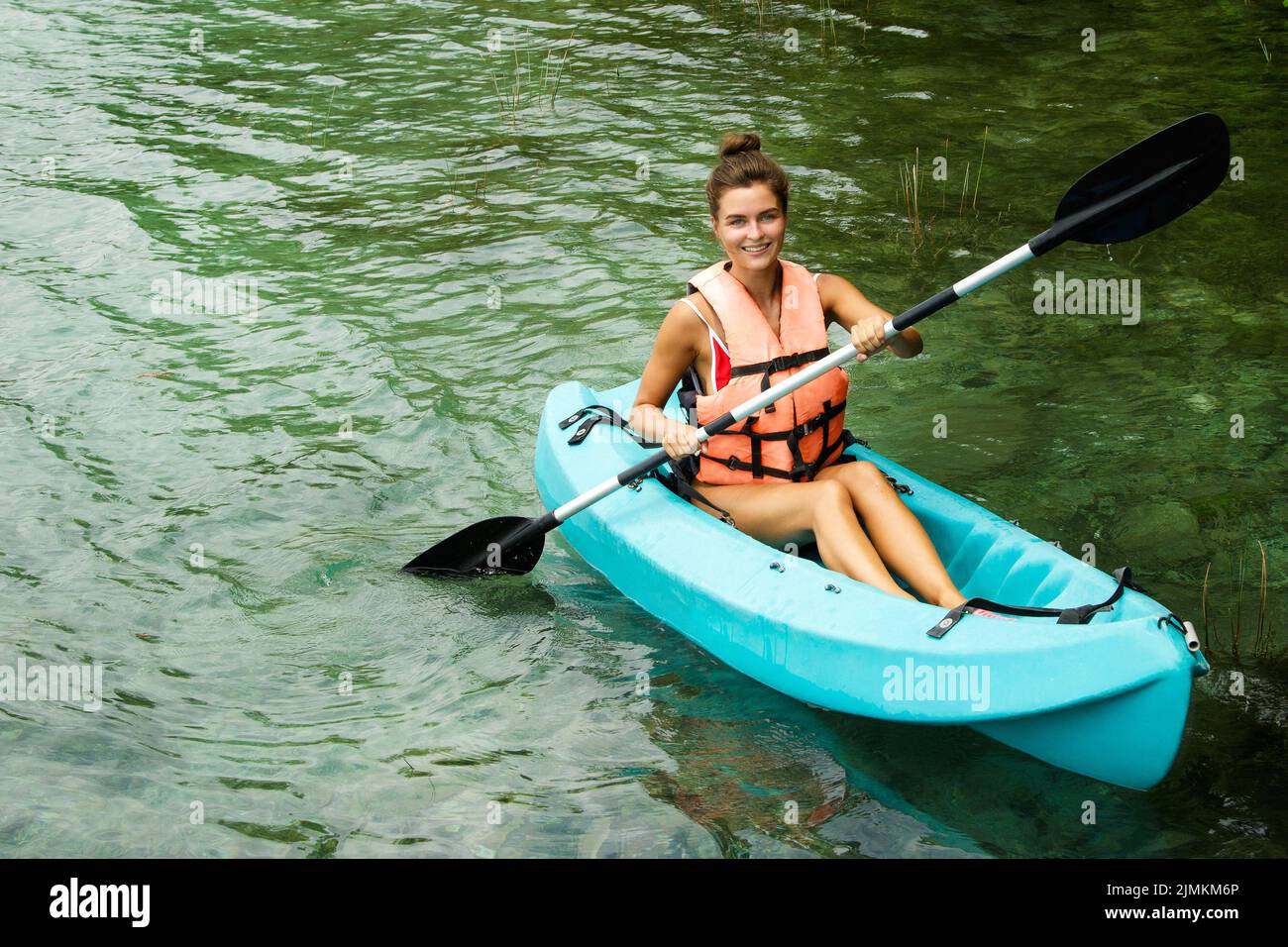 Glückliche junge Frau beim Kajakfahren auf dem See Stockfoto