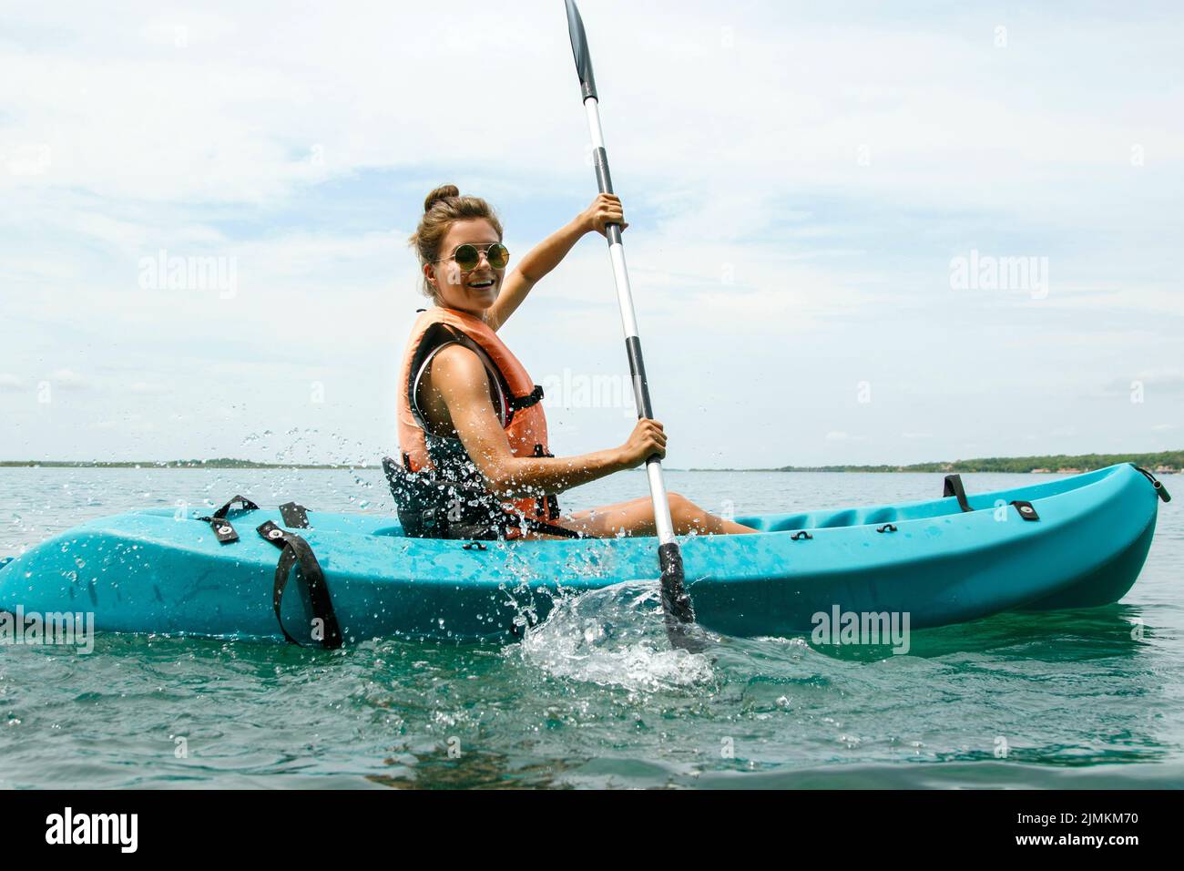 Glückliche junge Frau beim Kajakfahren auf dem See Stockfoto