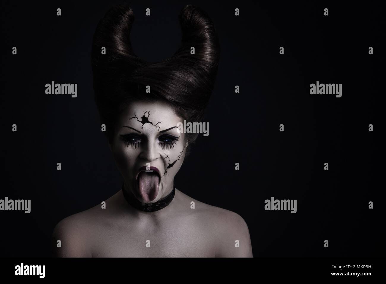 Gruselige Porzellanpuppe mit Hörnern auf ihrem Kopf. Stockfoto