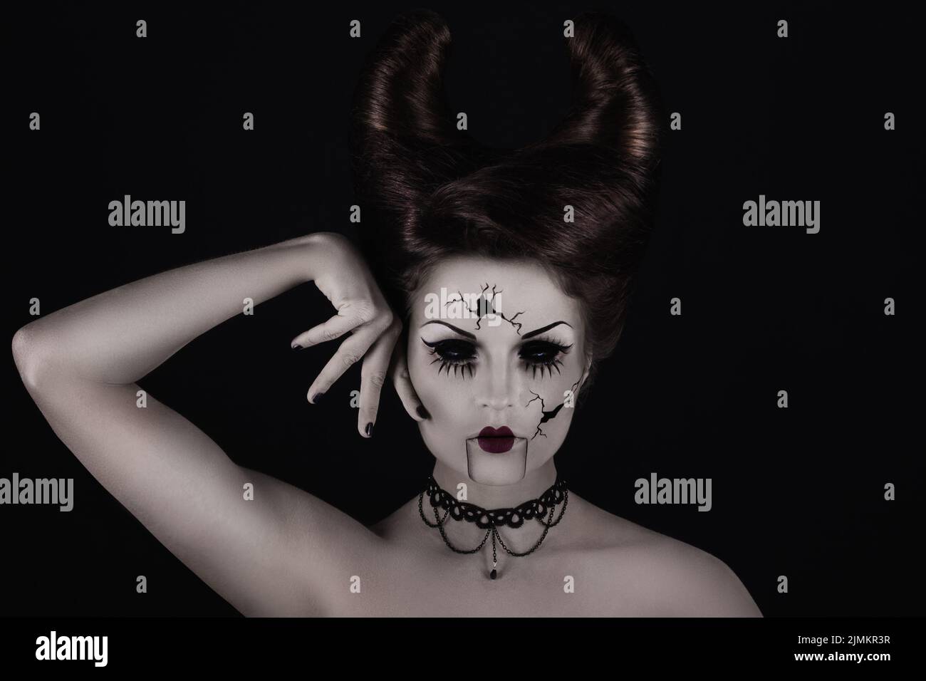 Gruselige Porzellanpuppe mit Hörnern auf ihrem Kopf. Stockfoto