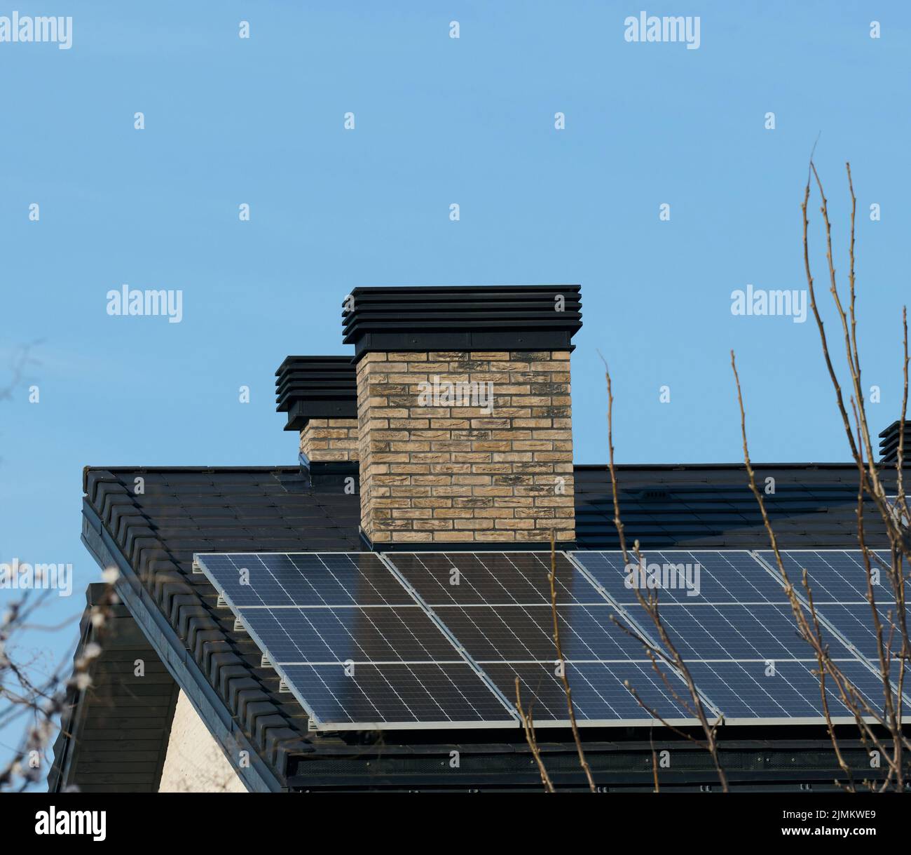 Dach eines Wohngebäudes mit Solarzellen. Konzept für grüne Energie und Energieunabhängigkeit Stockfoto