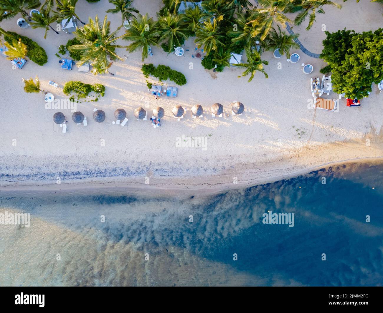 Drohnenblick auf einen Strand von oben in Mauritius, Drohnenblick mit Sonnenschirm und Sonnenbank auf dem ebach Stockfoto