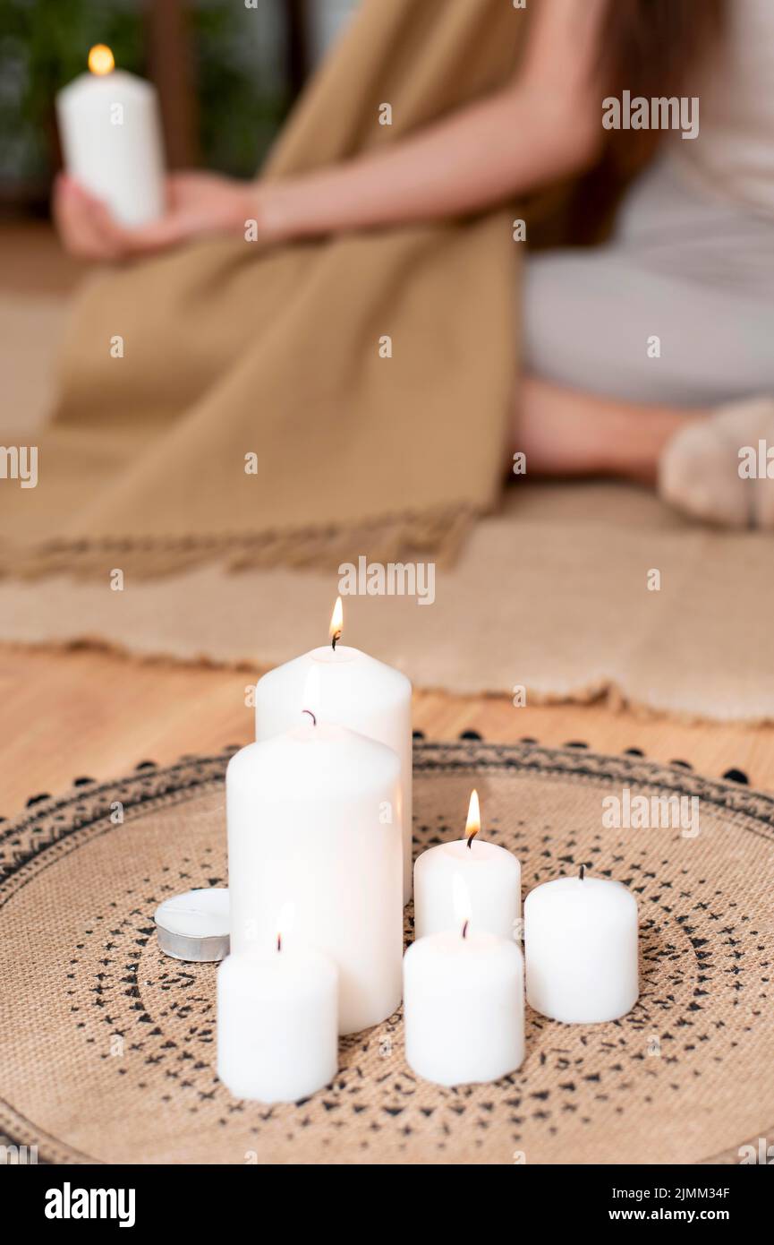 Frau meditiert mit Tablett mit Kerzen Stockfoto