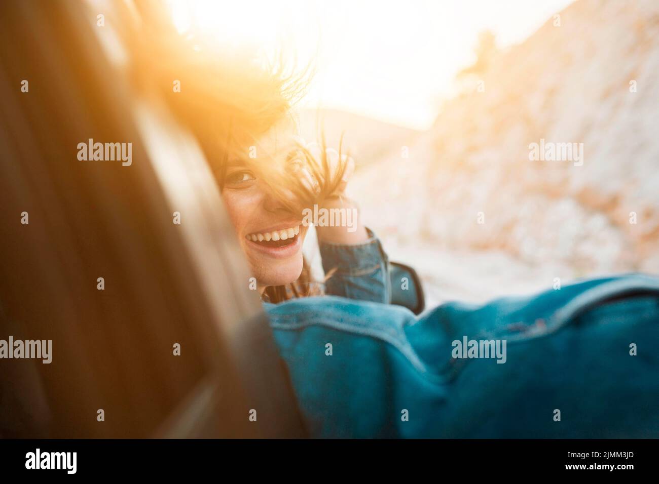 Frau lächelt während der Autofahrt Stockfoto
