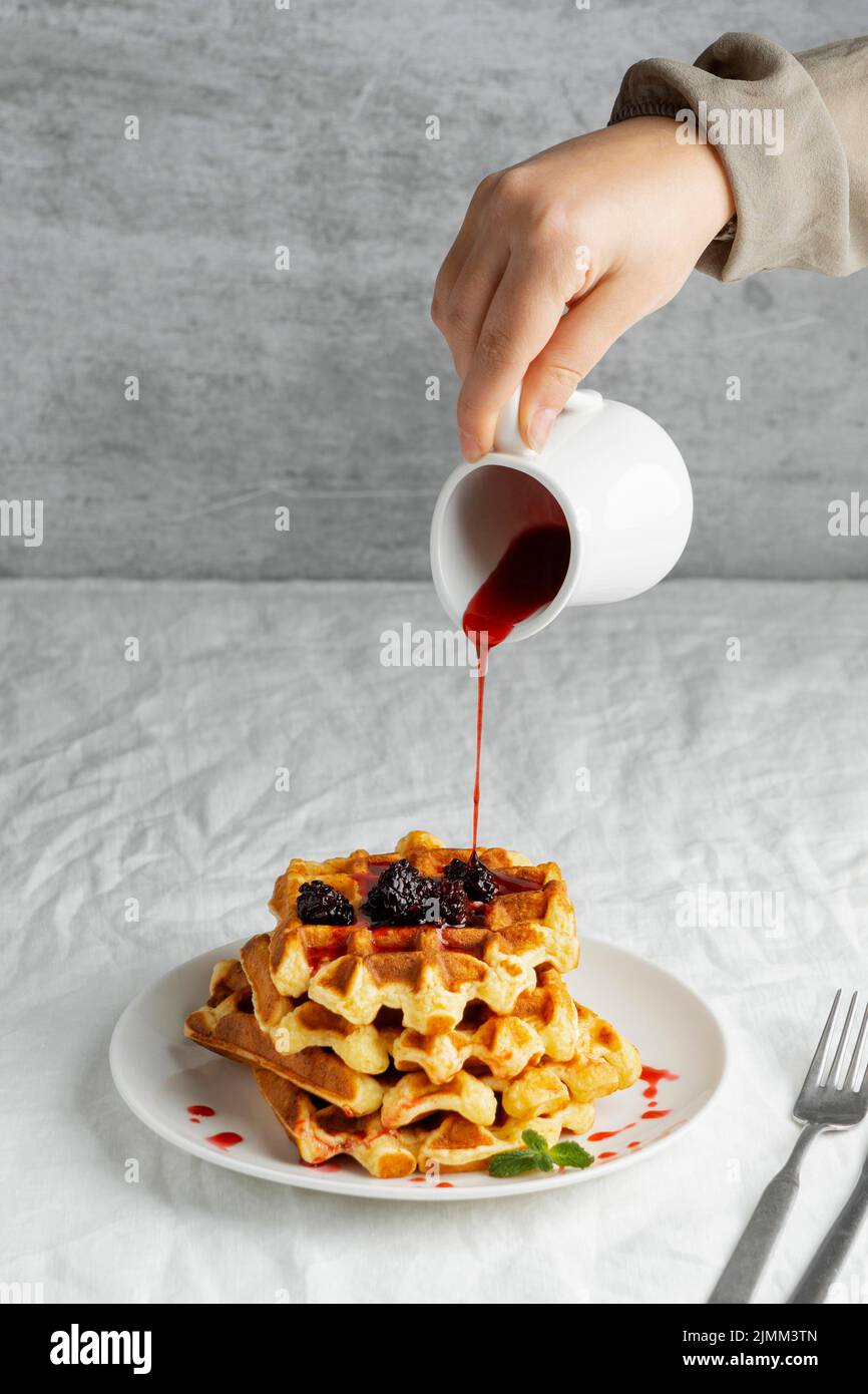 Nahaufnahme von Hand Gießen Sirup Stockfoto