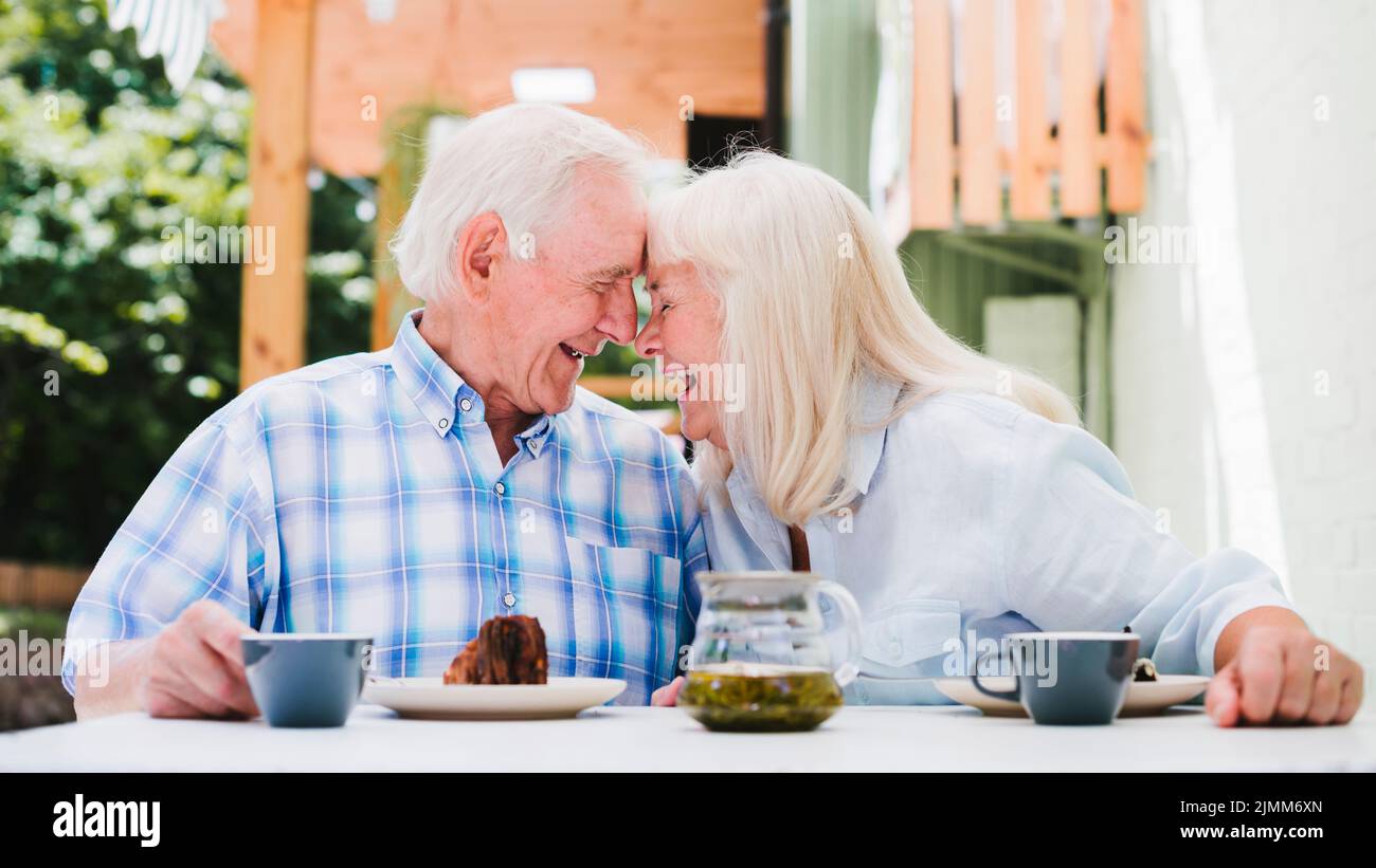 Ein älteres Paar sitzt mit Kopf und trinkt Tee Stockfoto