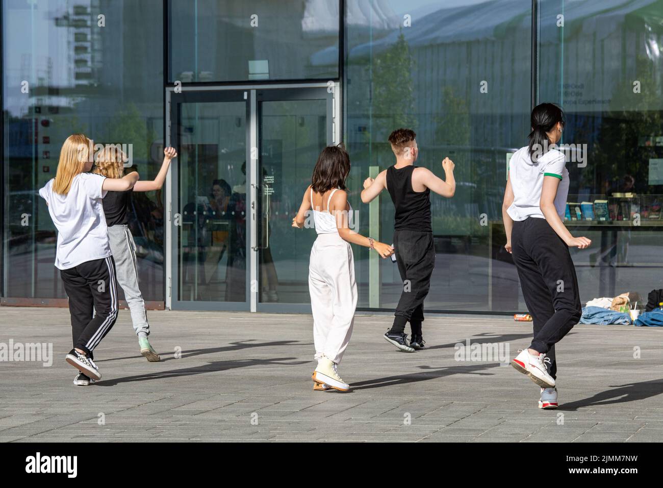 Jugendliche oder junge Erwachsene üben Tanzbewegungen vor der Oodi-Bibliothek in Helsinki, Finnland Stockfoto