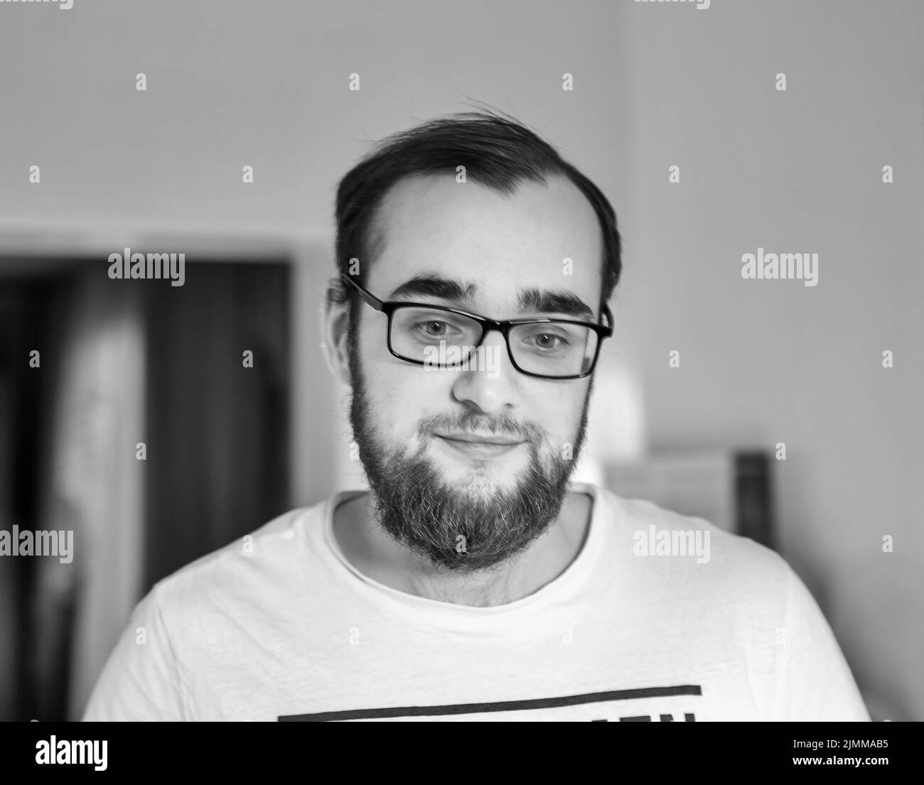 Schwarz-Weiß-Porträt eines Brillenmannes kaukasischer Ethnie mit Bart Stockfoto