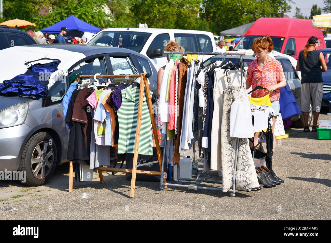 Heidelberg, Deutschland - August 2022: Frauen schauen auf dem Flohmarkt mit alten Second-Hand-Klamotten durch das Regal Stockfoto