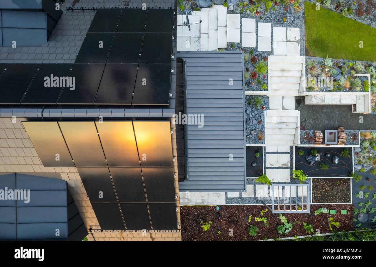 Modernes Haus mit Sonnenkollektoren und schönem Garten-Luftblick. Stockfoto