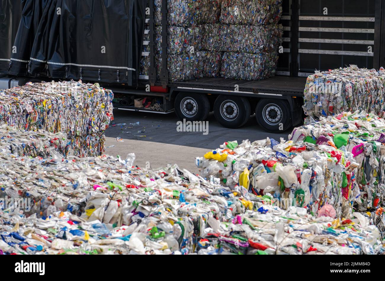 Gesammelt und sortiert PET-Flaschen und andere Kunststoffabfälle gehen an die Materialrückgewinnungs- und Recyclingeinrichtung. Sattelschlepper Beladen. Stockfoto