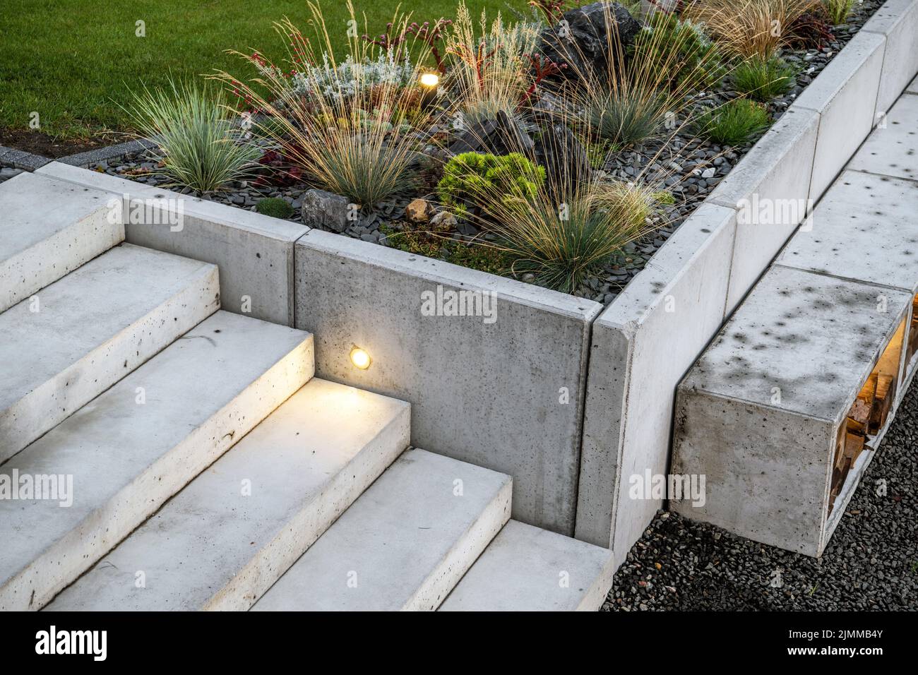 Moderner Steingarten und kleine Betonarchitektur. Beleuchtete Außentreppe Im Hinterhof. Stockfoto