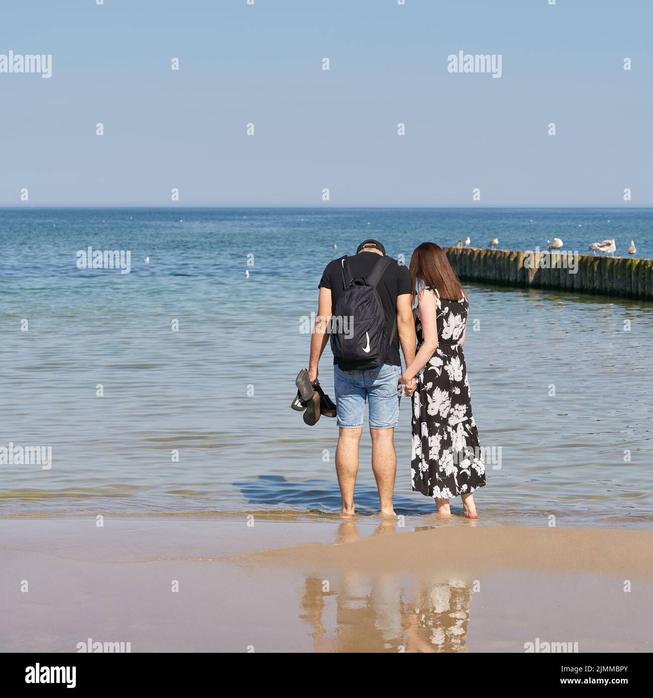 Junges Paar, das am Ostseestrand bei Kolobrzeg in Polen spazieren geht Stockfoto