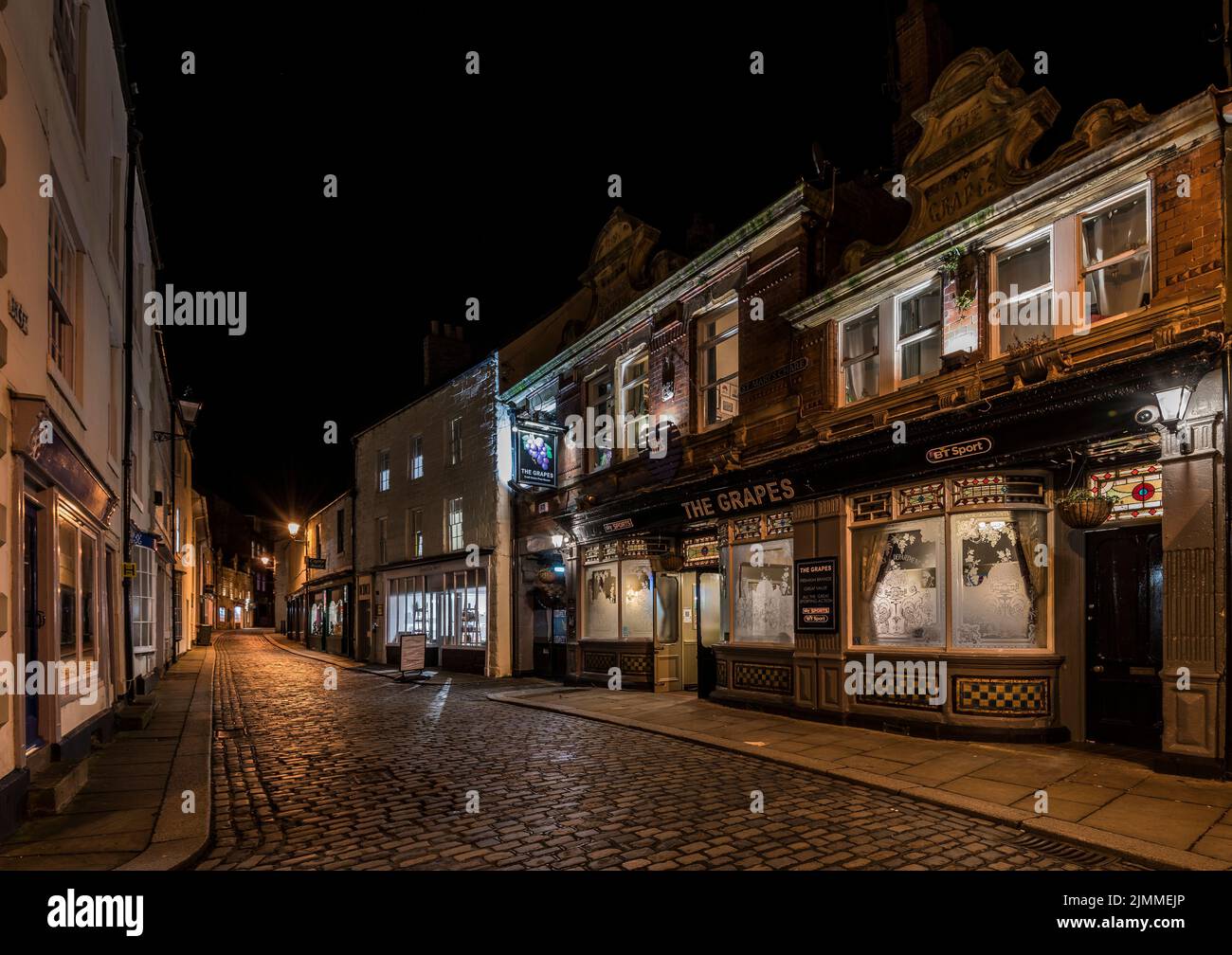 The Grapes Pub in einer verlassenen St Mary's Chare Street in Hexham, Northumberland, mit hellen Straßenlaternen und innenliegender Fensterbeleuchtung. Stockfoto