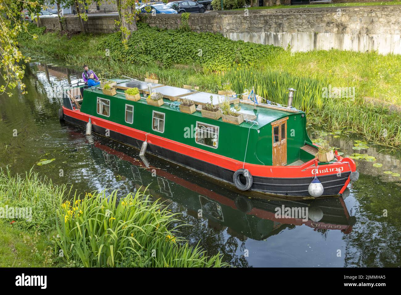 Eine schöne Aussicht auf ein Hausboot in einem Fluss mit grünem Gras Stockfoto