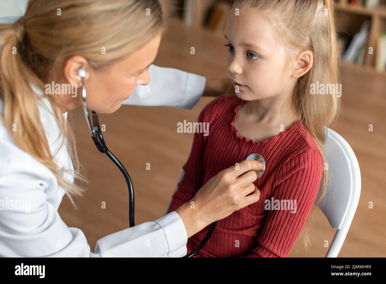Ärztin, die die Lungen des Kindes während der medizinischen Untersuchung überprüft, Kinderärztin, die Stethoskop verwendet, um kleine Patienten zu untersuchen Stockfoto