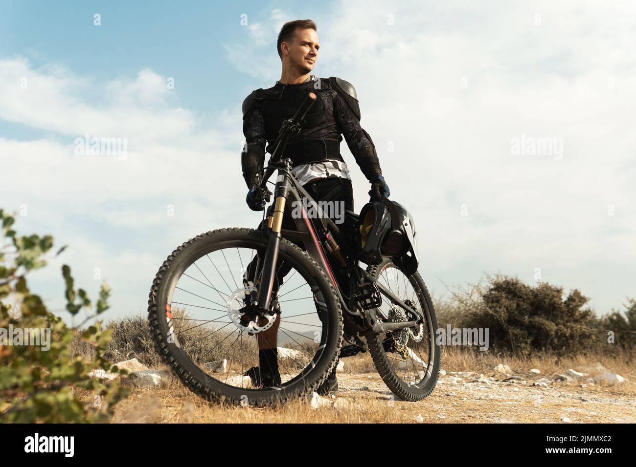 Downhillfahrer voll ausgestattet mit Schutzausrüstung und seinem Fahrrad Stockfoto
