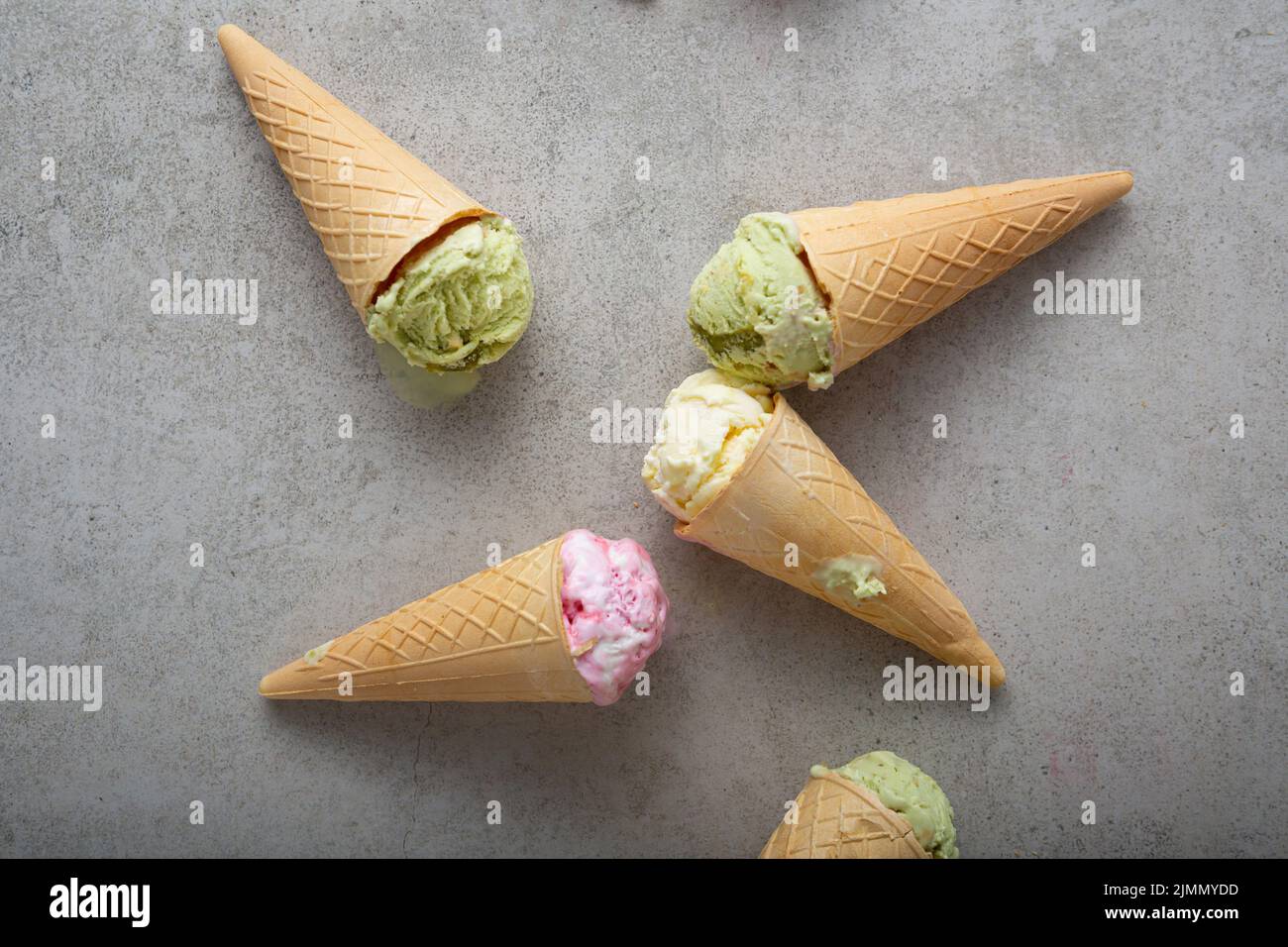 Blick von oben auf schmelzendes Eis Gelato Vanila Erdbeere Pistazie in Zapfen Stockfoto