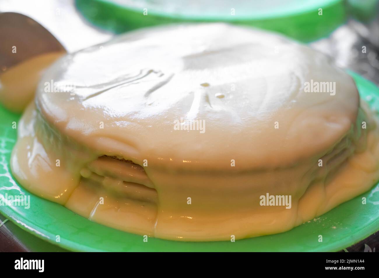 Kochen hausgemachten Kuchen. Die Backkuchenschichten sind mit Pudding bedeckt. Stockfoto
