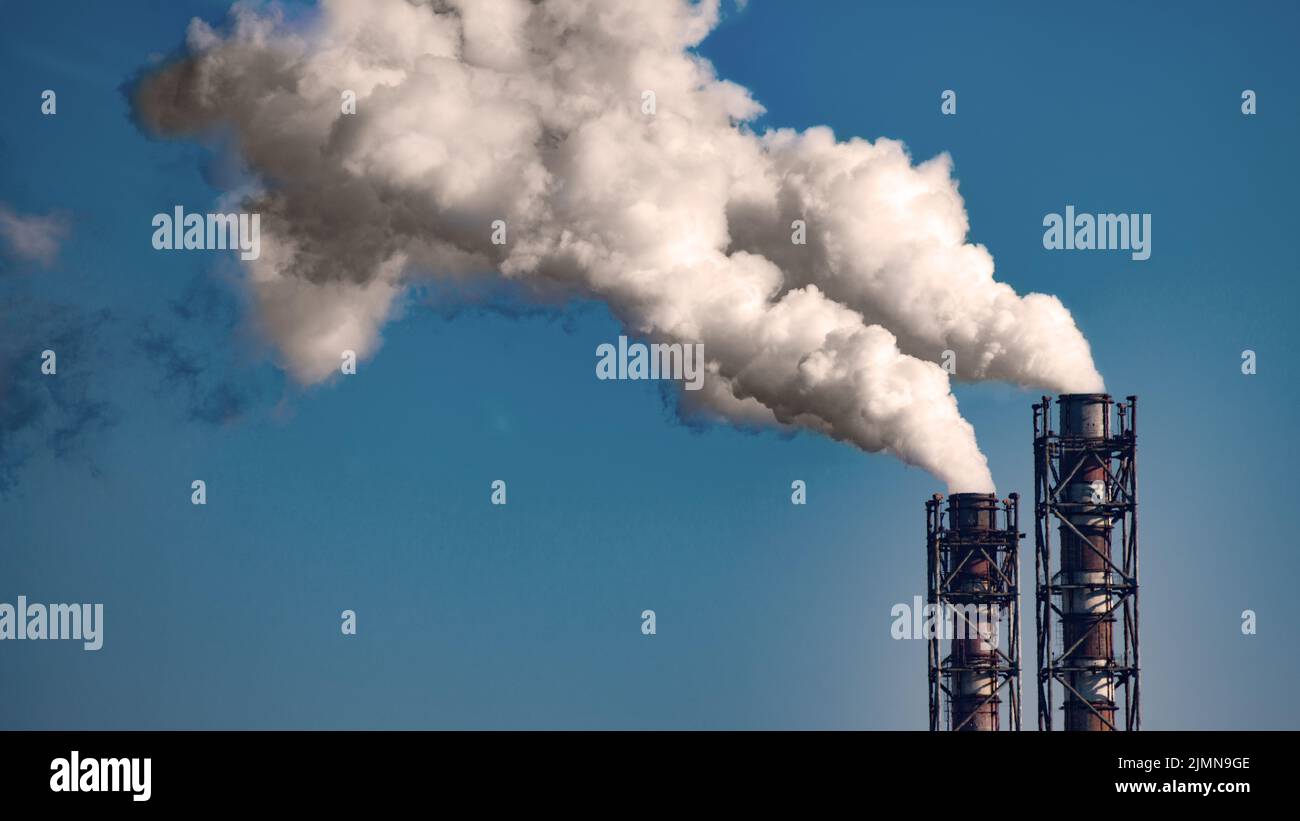 Rauchstapel des Kohlekraftwerks auf blauem Himmel Hintergrund. Für Text platzieren Stockfoto
