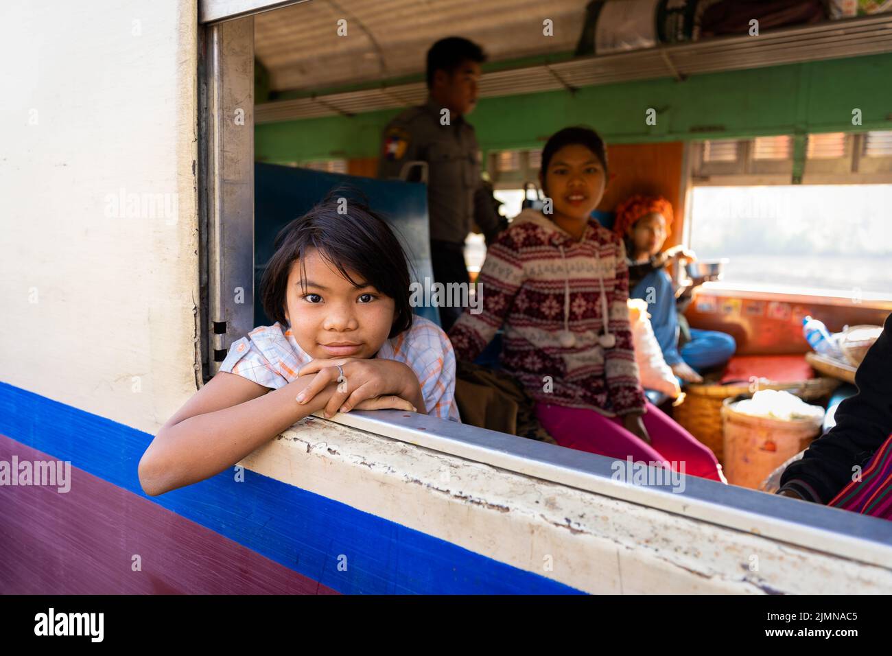 Ein Mädchen in einem lokalen Zug in Myanmar während des Tages Stockfoto