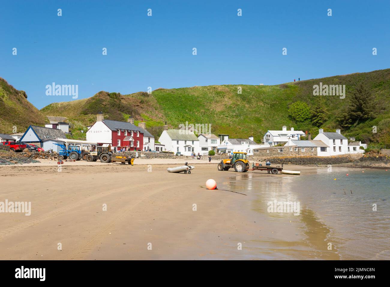 Porthdinllaen bei Morfa Nefyn an der Küste von Nord-Wales. Das bekannte Ty Coch Inn zwischen den weiß getünchten Hütten. Stockfoto