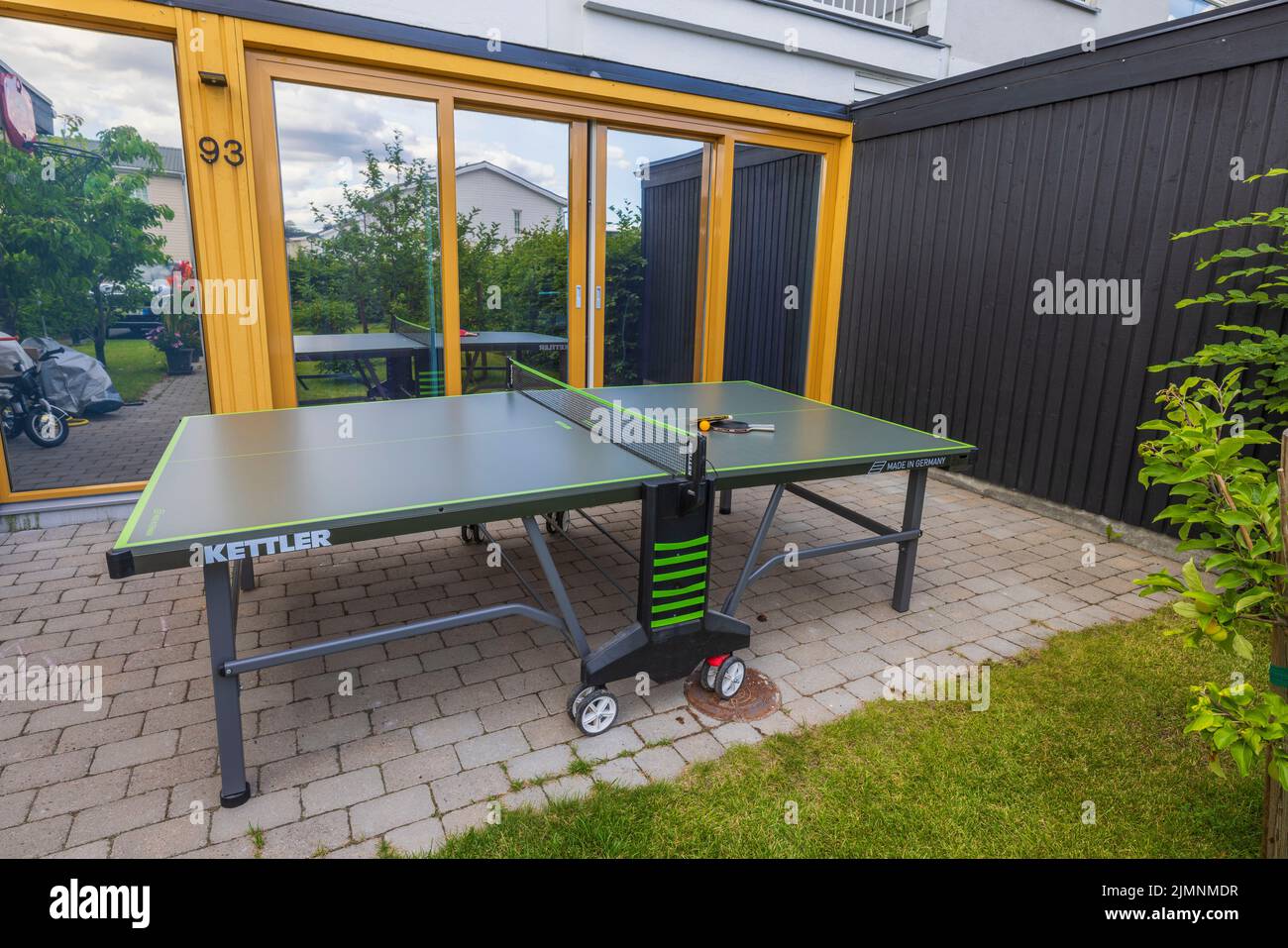 Schöne Aussicht auf die Tennistabelle mit Schlägern im Innenhof des Privathauses. Schweden. Uppsals. Stockfoto