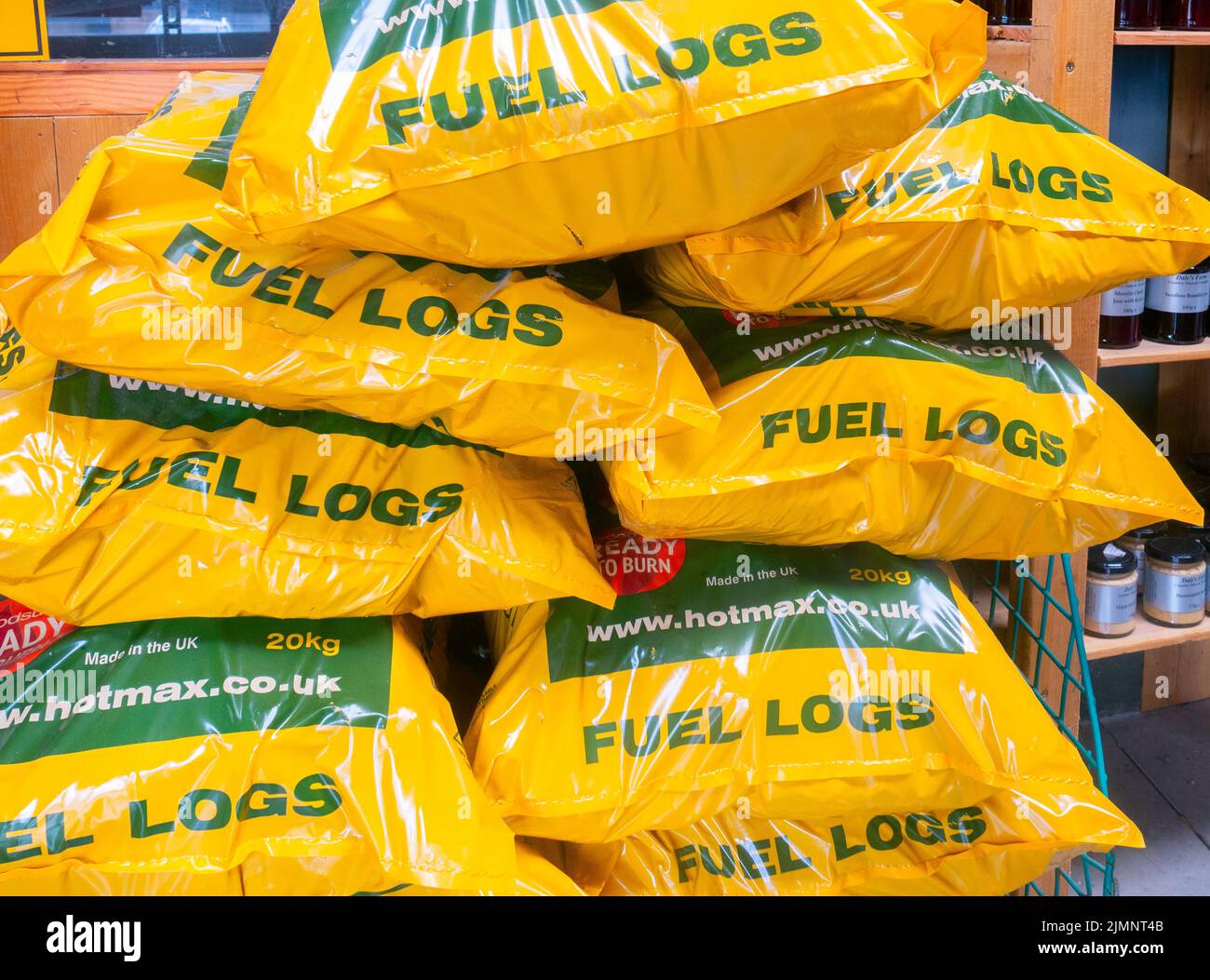 Winter-Kraftstoff-Plastiktüten mit trockenen Brennholzstämmen zum Verkauf in einem Bauernladen in North Yorkshire Stockfoto