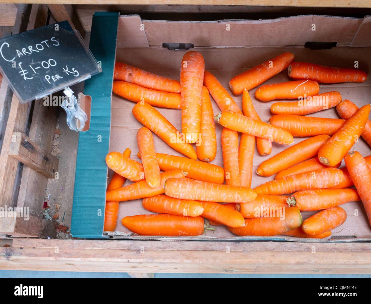 Frische, lokal angebaute Karotten zu einem Preis von £1,00 pro kg zum Verkauf in einem Bauernladen in North Yorkshire Stockfoto