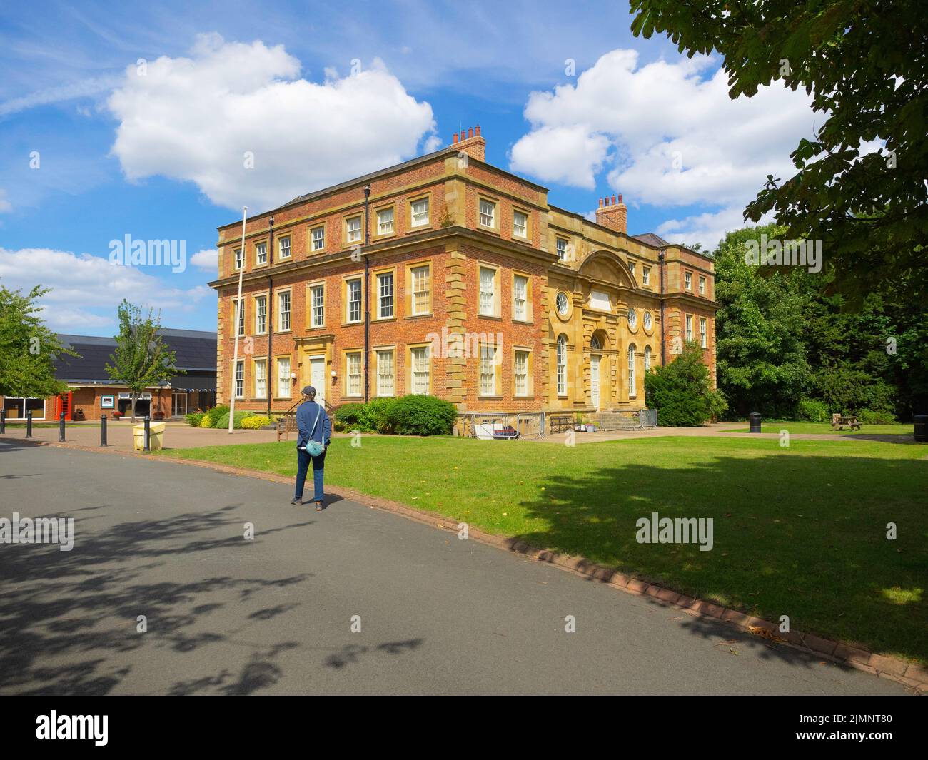 Ältere Frau, die am ehemaligen Wohnhaus der Familie Turner in Kirkleatham vorbeigeht, ist heute ein Museum der Geschichte von Redcar und Cleveland Stockfoto