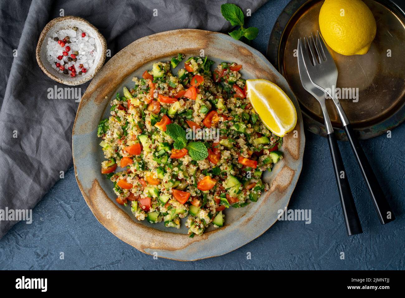 Tabbouleh Salat mit Quinoa. Östliche Speisen mit Gemüse mischen sich auf dunklem Tisch Stockfoto